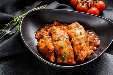 Domates soslu fırında halibut balığı. Siyah arka plan. Üst görünüm.