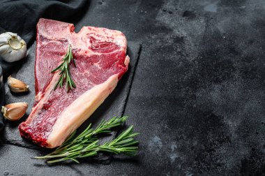 Biftek. Organik çiğ Tbon eti. Siyah arka plan. Üst Manzara. Boşluğu kopyala.