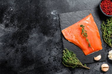 Kekikli taze çiğ somon filetosu. Siyah arka plan. Üst Manzara. Boşluğu kopyala.