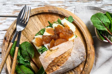 Keçi peynirli sandviç, armut reçeli, pazı ve baget ekmekli ıspanak. Beyaz ahşap arka plan. Üst görünüm.