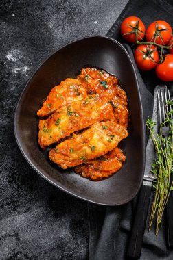 Domates soslu fırında halibut balığı. Siyah arka plan. Üst görünüm.