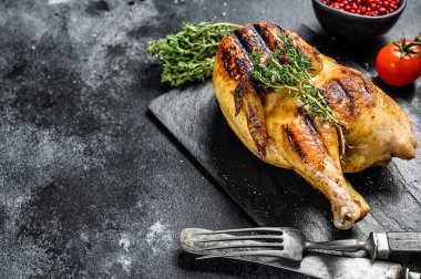 Kekikli ızgara organik tavuk. Siyah arka plan. Üst Manzara. Boşluğu kopyala.