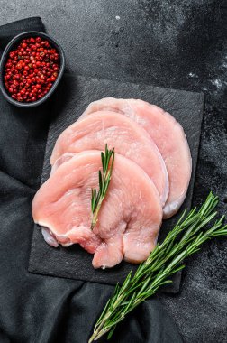 Çiğ hindi göğsü bifteği. organik kümes hayvanları. Siyah arka plan. Üst görünüm.