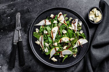 Armut, mavi peynir, roka ve fındık salatası. Siyah arka plan. Üst görünüm.