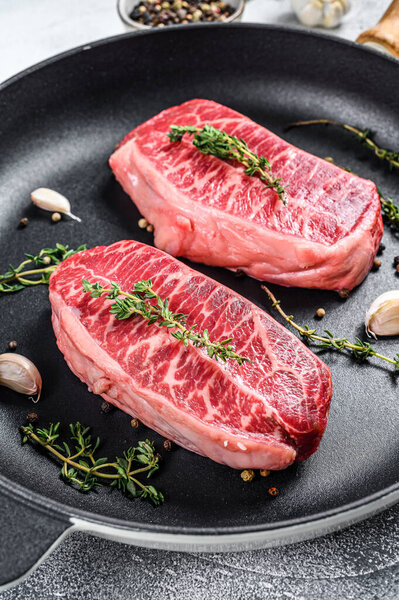 Raw marbled beef steak, top blade meat steak. Gray background. Top view.