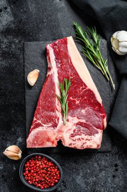 Biftek. Organik çiğ Tbon eti. Siyah arka plan. Üst görünüm.