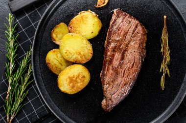 Kızarmış salamura biftekli biftek. Siyah arka plan. Üst görünüm.