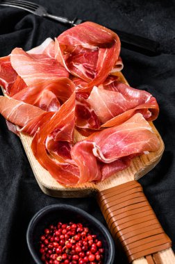 Prosciutto Crudo, İtalyan salamı, parma jambonu. Antipasto tabağı. Siyah arkaplan, üst görünüm