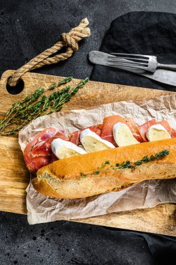 Jamon jambonlu sandviç, paleta iberica, kesim tahtasında Camembert peyniri. Siyah arkaplan, üst görünüm