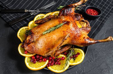 Portakal ve Rosmarina ile doldurulmuş fırında kaz. Kutlama masası. Siyah arka plan. Üst Manzara. Metin için boşluk.