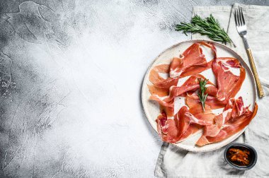 İspanyol jamonu Serrano, jambon. Antipasto tabağı. Gri arkaplan, üst görünüm, metin için boşluk.