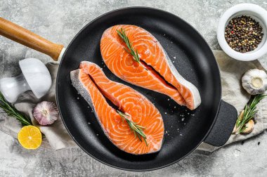 Tavada taze somon bifteği. Sağlıklı deniz ürünleri. Gri arka plan. Üst görünüm.