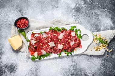 Çiğ mermerden yapılmış Carpaccio. Gri arka plan. Üst Manzara. Metin için boşluk.