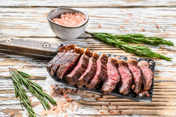 Grilled ramp cap steak on a meat cleaver. White wooden background. Top view — Stock Photo, Image