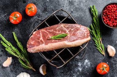 Izgarada çiğ biftek var. Siyah arka plan. Üst görünüm