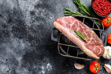 Izgarada çiğ biftek var. Siyah arka plan. Üst Manzara. Boşluğu kopyala.