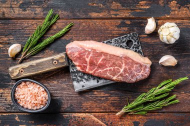 Et satırında çiğ biftek. Koyu ahşap arka plan. Üst görünüm.