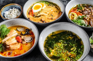 Geleneksel Asya çorbaları. Miso, Ramen, Tom Yam, Pho Bo. Siyah arka plan. Üst görünüm.