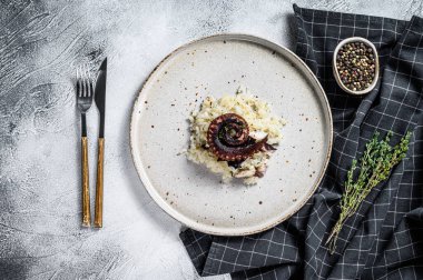 Ahtapot dokunaçlı İtalyan klasik Risotto. Beyaz gri arka plan. Üst görünüm.