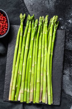 İşlenmiş masada bir sürü taze kuşkonmaz. Siyah arka plan. Üst görünüm.