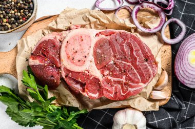 Çiğ dana şişi, Osso Buco baharat ve bitkilerle. OssoBuco eti. Gri arka plan. Üst görünüm.