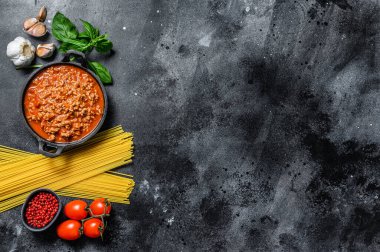 Domatesli makarna, bolonez soslu, peynirli ve fesleğenli makarna pişirme fikri. Siyah arka plan. Üst Manzara. Boşluğu kopyala.