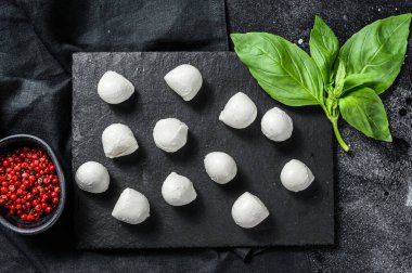Mini mozarella peyniri topları, Caprese salatası için malzemeler. Siyah arka plan. Üst görünüm.