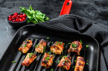 Domuz pastırmasına sarılmış kızarmış tavuk göğsü. Siyah arka plan. Üst görünüm