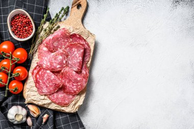Çiğ tütsülenmiş salam sosisi dilimleri. Gri arka plan. Üst Manzara. Boşluğu kopyala.