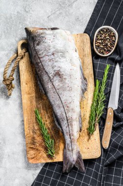 Kesme tahtasındaki taze mezgit balığı leşi. Gri arka plan. Üst görünüm.