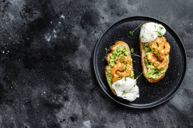 Ekmek, avokado, karides, karides ve rafadan yumurta ile sandviç. Siyah arka plan. Üst Manzara. Boşluğu kopyala.