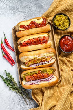 Tepside çeşitli malzemelerle dolu sosisliler. Domuz ve sığır etli sosisli nefis sosisler. Beyaz arka plan. Üst görünüm.