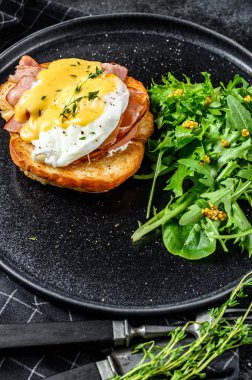 Pastırmalı kahvaltı burgeri, Benedict yumurtası, brioche ekmeğine Hollandaise sosu. Siyah arka plan. Üst görünüm.