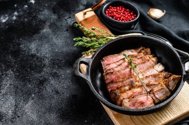 Kemiğe baharat ve otlarla dilimlenmiş domuz pirzolası. Siyah arka plan. Üst Manzara. Boşluğu kopyala.