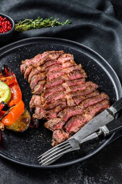 Yanında sebze tabağı olan bir tabakta Chuck 'ın göz yuvarlaması. Siyah arka plan. Üst görünüm.