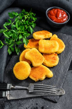 Tahtaya tavuk nugget ve ketçap sosu. Karanlık arka plan. Üst görünüm.