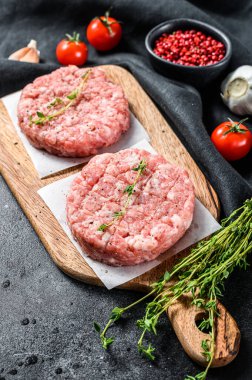 Çiğ tavuk köftesi, kıyma tahtasında kıymalı pirzola. Organik kıyma. Siyah arka plan. Üst görünüm.