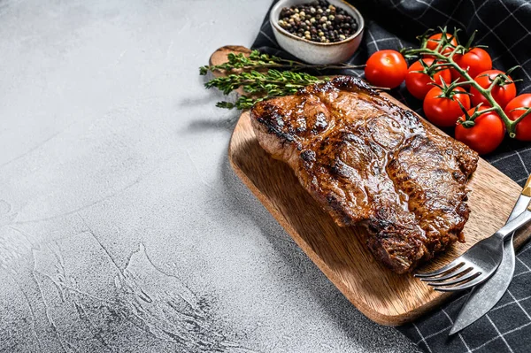 Geroosterde Varkenssteak Een Snijplank Biologisch Vlees Grijze Achtergrond Bovenaanzicht Kopieerruimte — Stockfoto