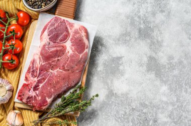 Doğrama tahtasında çiğ domuz eti. Gri arka plan. Üst Manzara. Boşluğu kopyala.