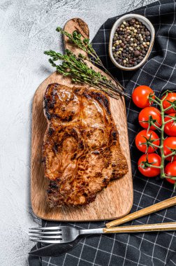 Kemiğin üzerinde baharat ve bitkilerle domuz pirzolası. Gri arka plan. Üst görünüm.