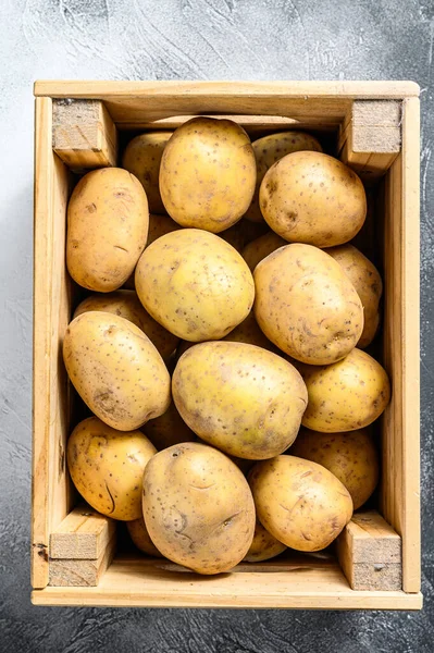 Ακατέργαστες Πατάτες Ένα Παλιό Ξύλινο Κουτί Ένα Τραπέζι Γκρι Φόντο — Φωτογραφία Αρχείου