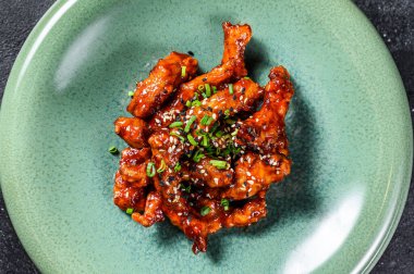 Asya yemeği: tatlı ve ekşi soslu baharatlı domuz eti. Siyah arka plan. Üst görünüm.