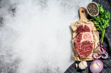 Çiğ ossobuco con ve şifalı otlar. Osso buco sığır eti. Siyah arka plan. Üst Manzara. Boşluğu kopyala.