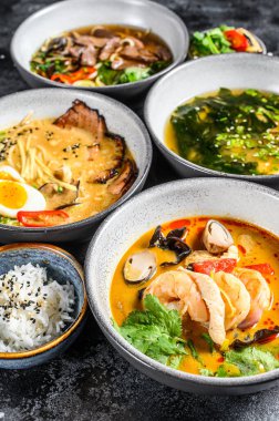 Geleneksel Asya çorbaları. Miso, Ramen, Tom Yam, Pho Bo. Siyah arka plan. Üst görünüm.