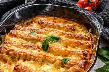 Beşamel soslu doldurulmuş cannelloni. Etli makarna, krem soslu, peynirli. Gri arka plan. en üstteki görünüm.