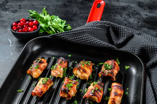 Domuz pastırmasına sarılmış kızarmış tavuk göğsü. Siyah arka plan. Üst görünüm