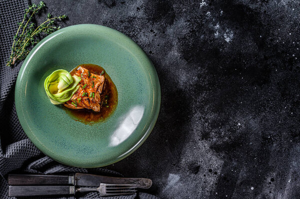 salmon fillet tataki with avocado garnish. Black background. Top view. Copy space.