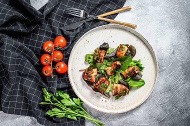 Doldurulmuş tavuk göğsü, domuz pastırması ve yeşil salata. Gri arka plan. Üst görünüm.