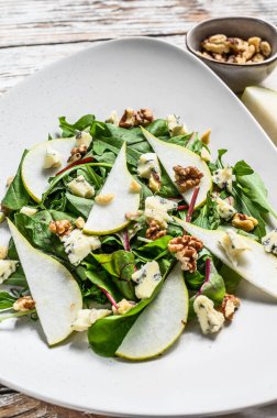 Mavi peynirli salata, armut, fındık, pazı ve roka. Beyaz arka plan. Üst görünüm.