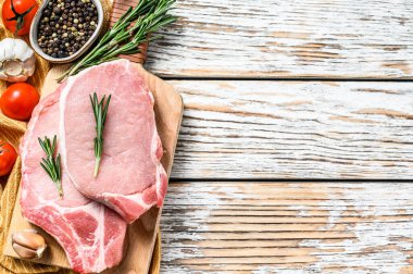 Çiğ domuz pirzolası. Organik et. Beyaz ahşap arka plan. Üst Manzara. Boşluğu kopyala.